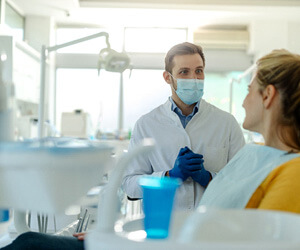 dentist talking to smiling patient at appointment